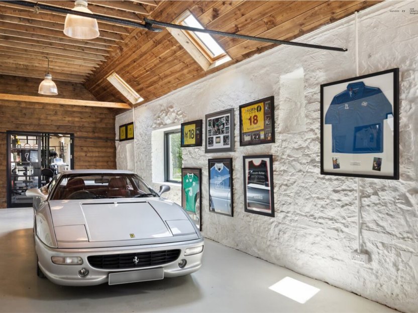Garaje privado con Ferrari y colección personal enmarcada, ejemplo de vivienda de lujo personalizada
