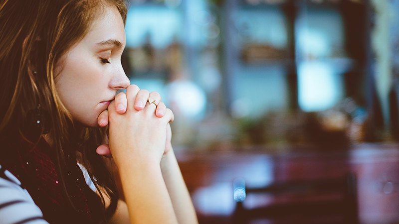 woman praying, featured image for the article 