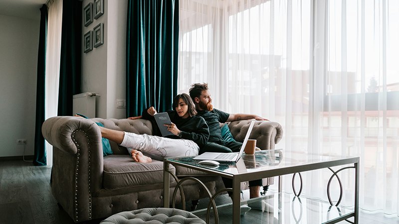 a couple relaxing in the living room of their new house, representing the article Buying a House in Spain as a US Citizen A Comprehensive Guide