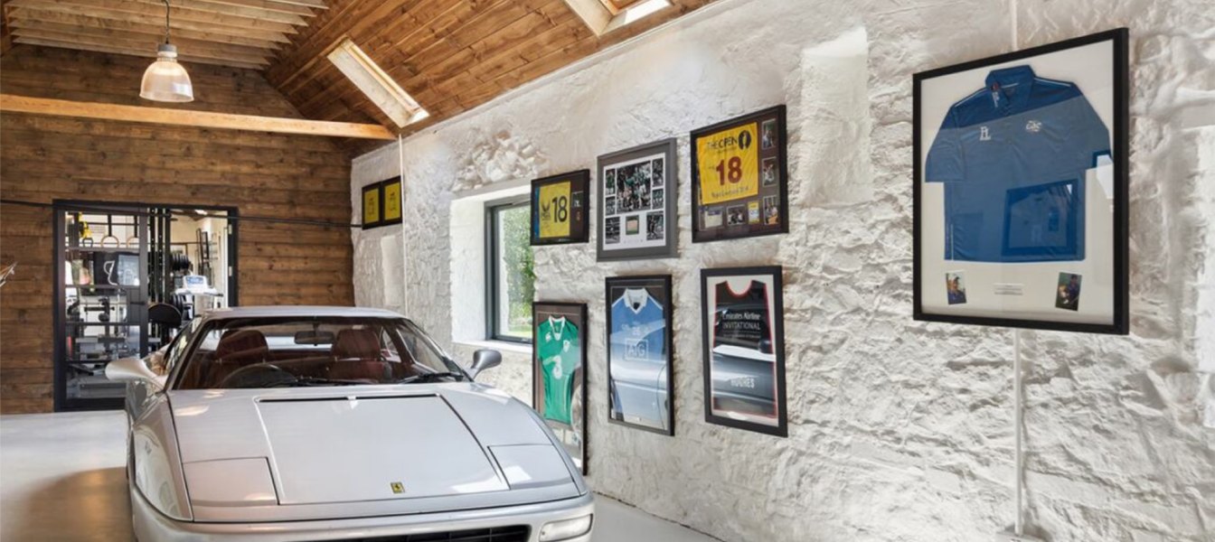 Garaje privado con Ferrari y colección personal enmarcada, ejemplo de vivienda de lujo personalizada