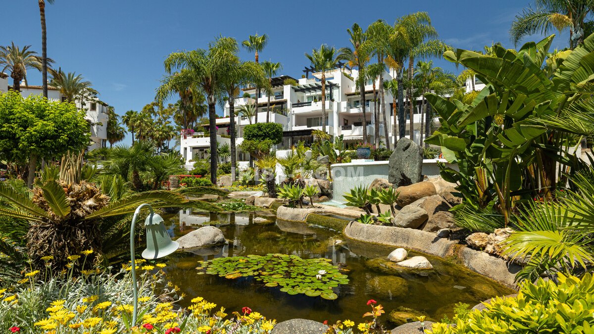 Exquisite beachside apartment in Marina Puente Romano's prestigious Japanese Gardens with private terrace and resort amenities.