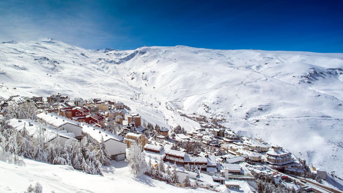 Village of Pradallano covered in show - pine trees and ski village in snow, Sierra Nevada, Granada, Andalucía, south of Spain, 