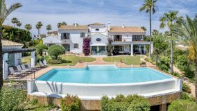 Lujosa villa de estilo andaluz de 1.032 m2 construida en una parcela de 3.247 m2 anexa a otra parcela de 2.859 m2 con vistas al campo de golf y al mar, rodeada de patios y una amplia zona ajardinada en Sotogrande Alto.