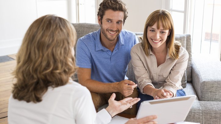 a group of people sitting around a table looking at a tablet, featured image for the article