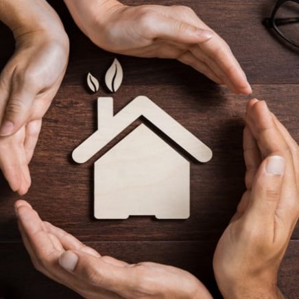 manos y casa simbolizando un hogar más sostenible