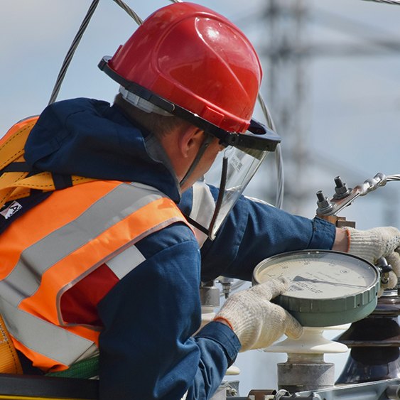 lineman at work wearing a protective helmet and vest, featured image for the article