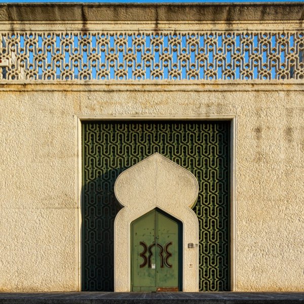 Stunning arched doorway with intricate geometric patterns on an elegant textured facade.