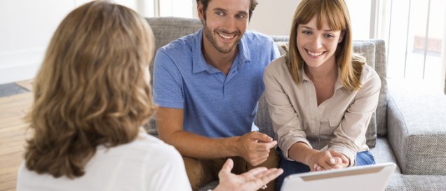 a group of people sitting around a table looking at a tablet, featured image for the article 