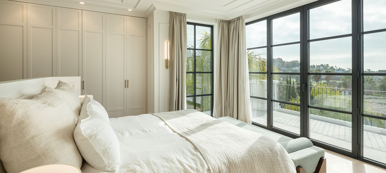 Serene bedroom in a Marbella villa, featuring abundant natural light and biophilic design elements that enhance wellbeing and comfort.