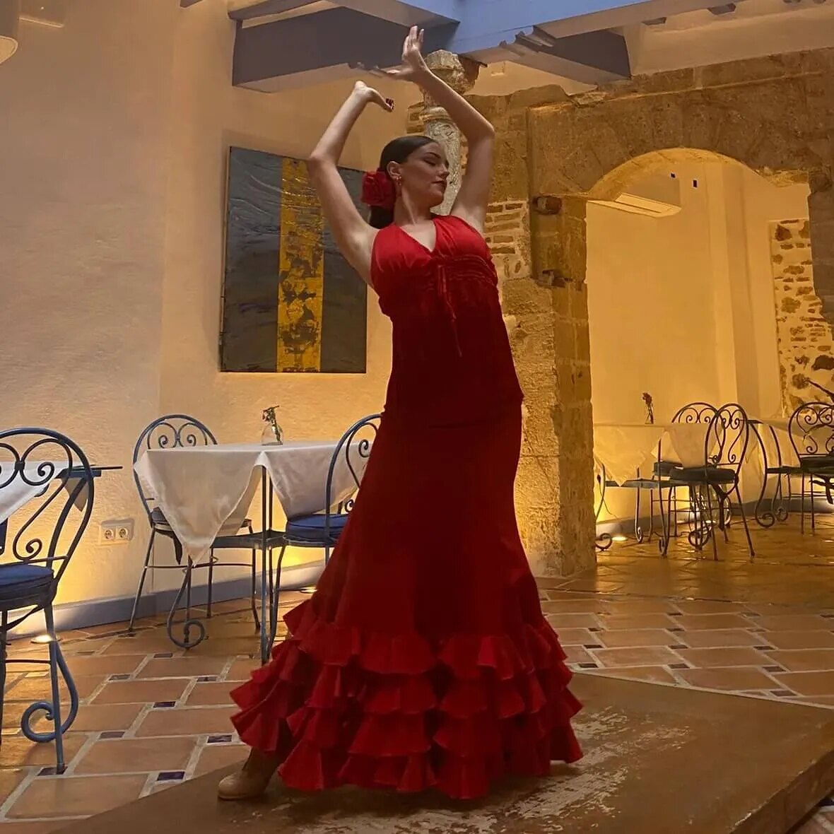 Flamenco dancer performing at a Marbella cultural event with local wine glasses on a table.