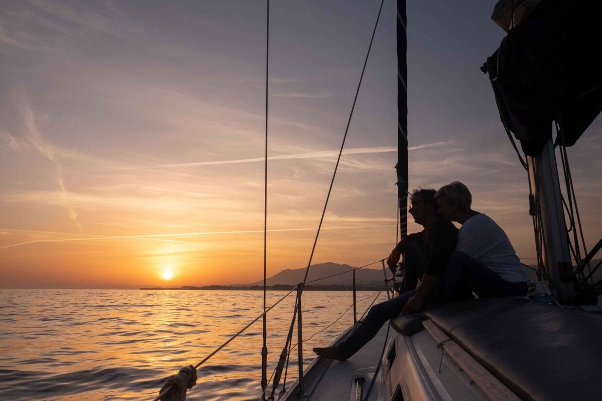 Couple enjoying sunset on boat overlooking Golden Mile Marbella promenade