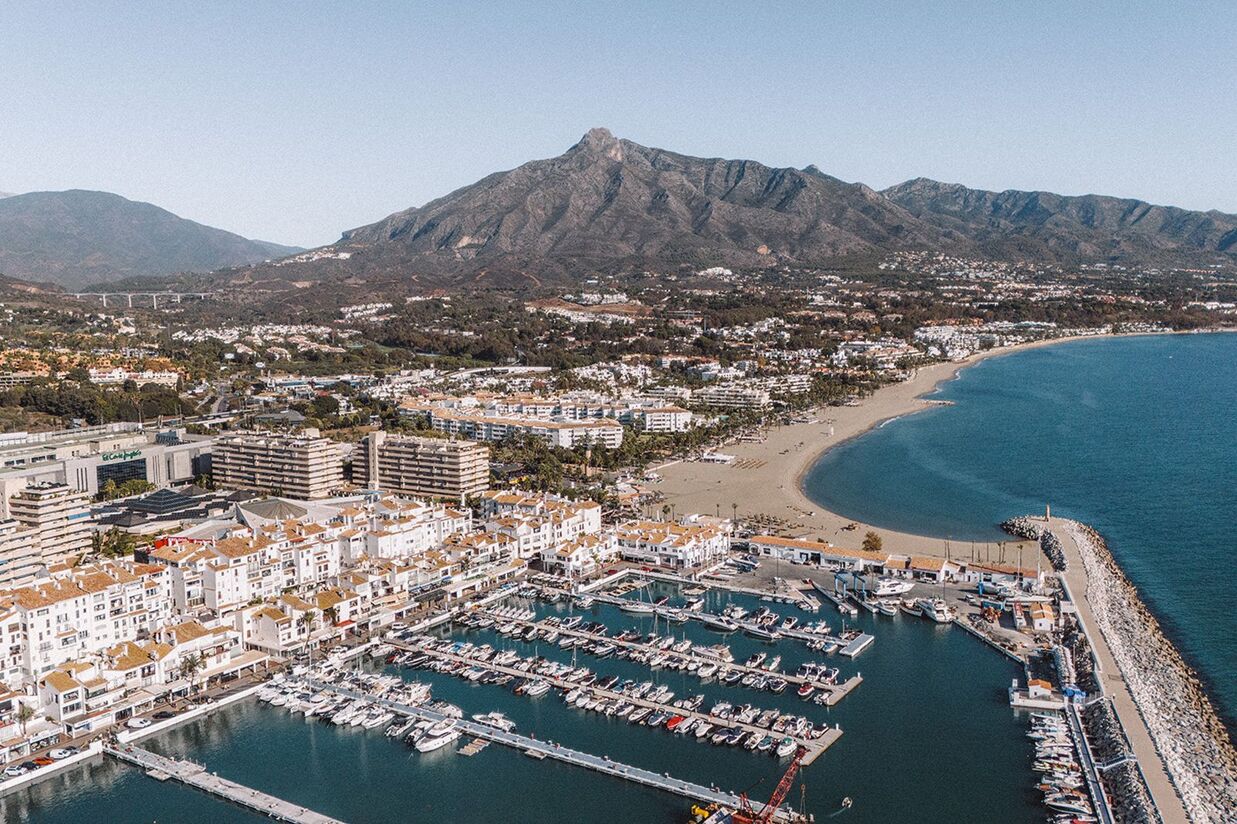 Aerial drone view of sunny Marbella coastline and surrounding mountains on the Costa del Sol