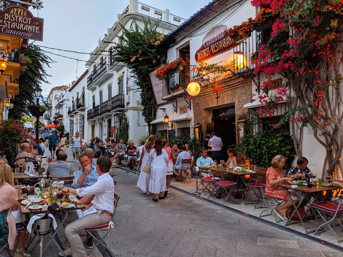 Marbella Old Town street with restaurants, flowers and traditional Andalusian architecture