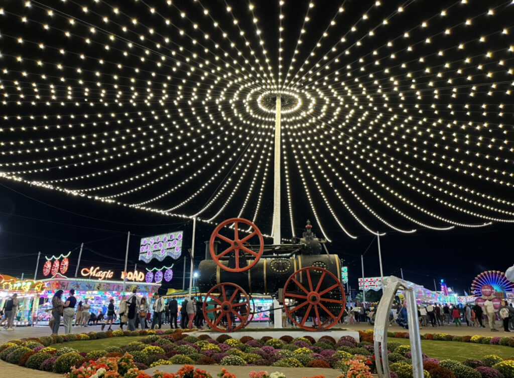 San Pedro fair at night with decorative lights and traditional attractions