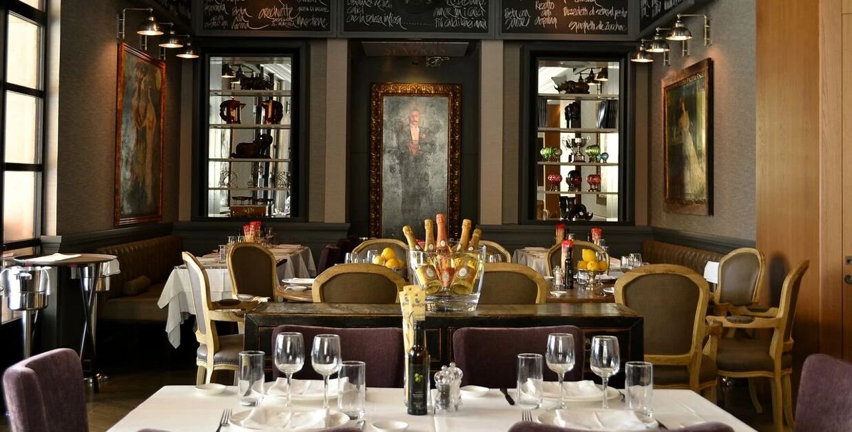Elegant interior of Trattoria L’Impronta restaurant with classic dining setup