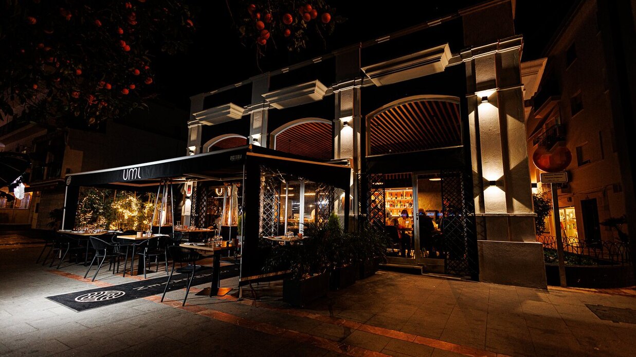 Exterior of Umi Marbella restaurant at night with outdoor seating and warm lighting
