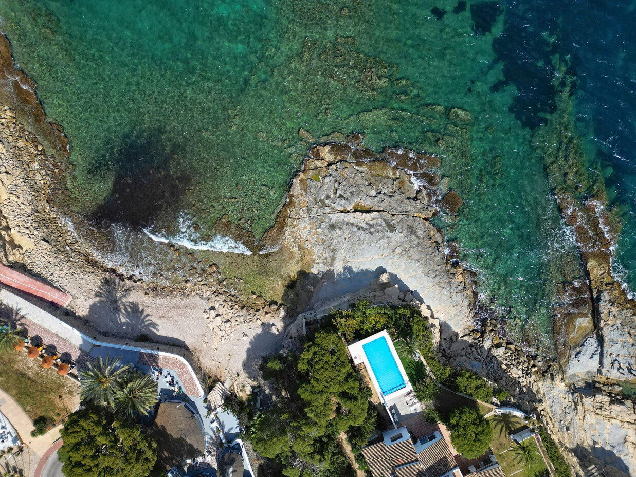 Aerial view of a turquoise cove in Mallorca showcasing the Mediterranean lifestyle that attracts Scandinavian property buyers.