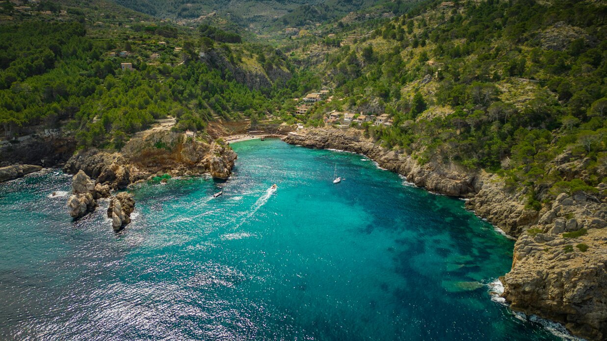 Aerial view of Mallorca coastline with turquoise waters and rugged cliffs.