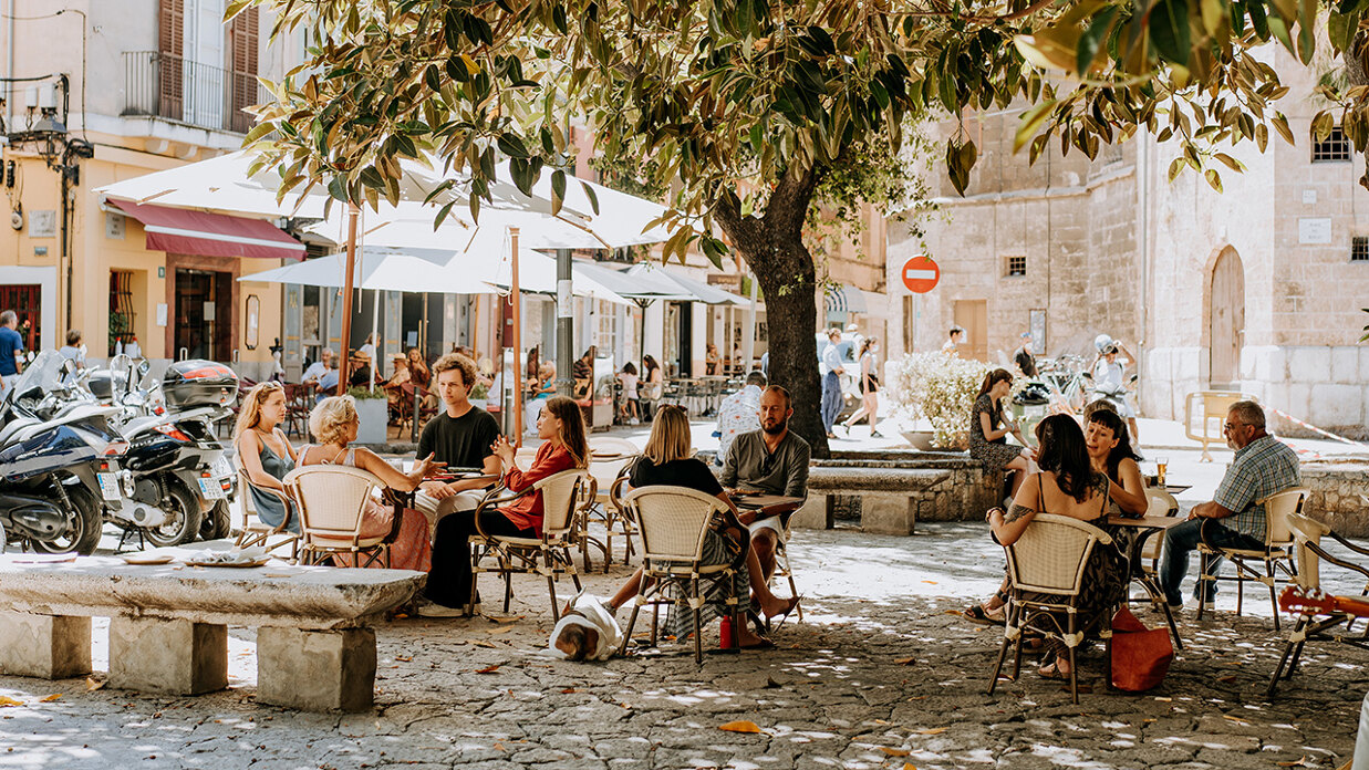People enjoying fine dining in Palma de Mallorca Old Town with cathedral in the background.