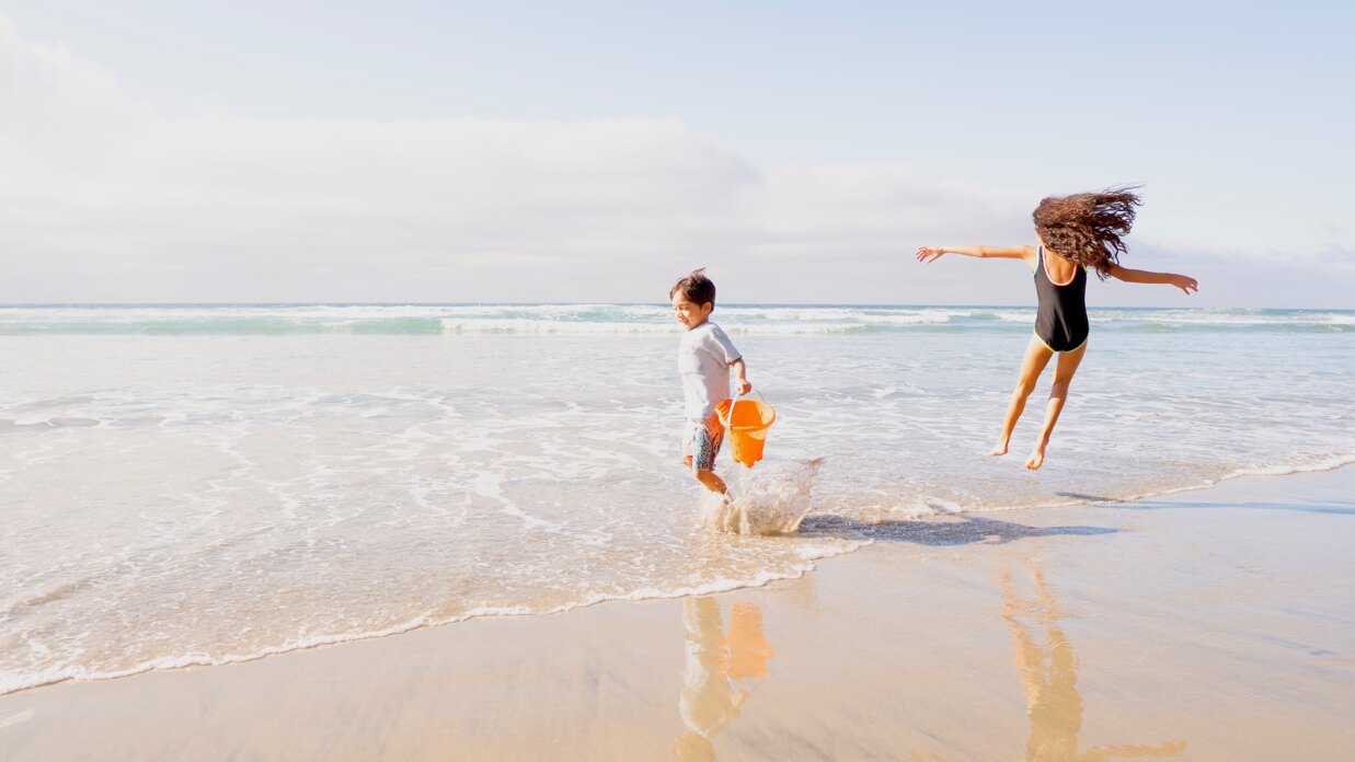 Family on a Mallorca beach under the sun, with blue sea and relaxed atmosphere.