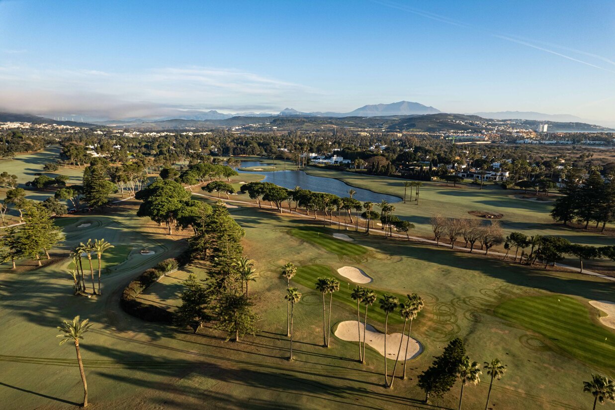 Luxury golf course in Sotogrande with lakes, fairways and surrounding Mediterranean landscape.