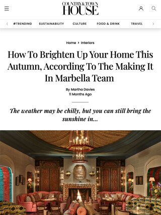 Bright living room with arched windows, white plaster walls, wooden ceiling beams, and terracotta flooring