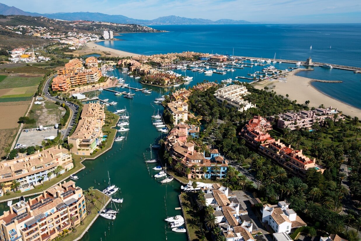 Aerial view of Sotogrande Marina with yachts, waterfront apartments, and modern design.