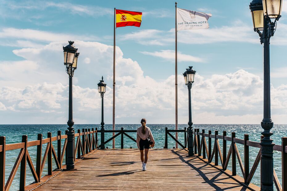 Photograph of woman walking on the Marbella Club Pier next to Puente Romano in Marbella 