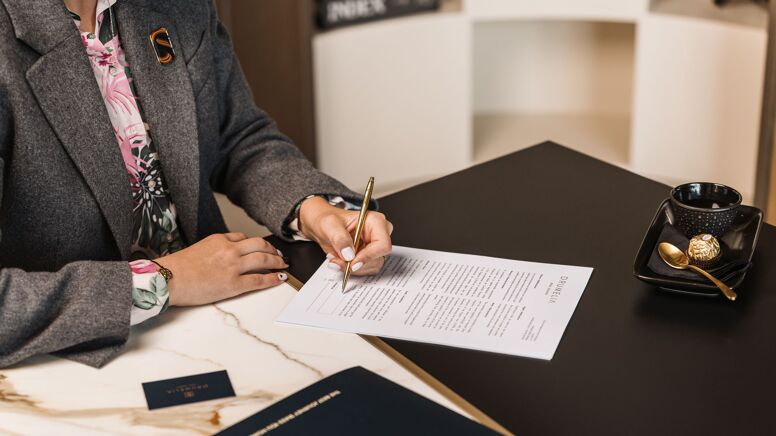 Photograph of a Drumelia Real Estate Agent signing a contract in Marbella 