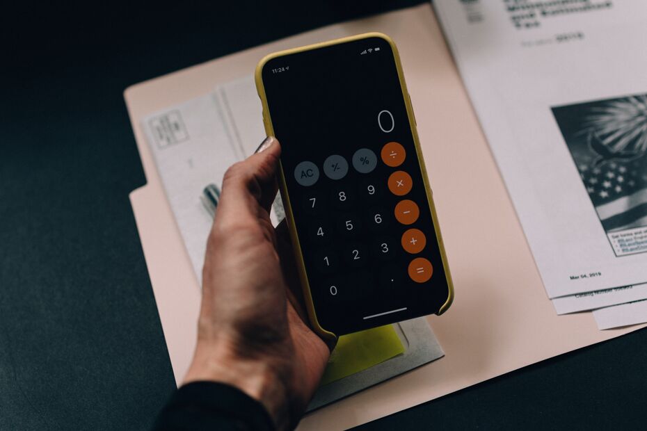 Photograph of someone using a calculator and doing paperwork