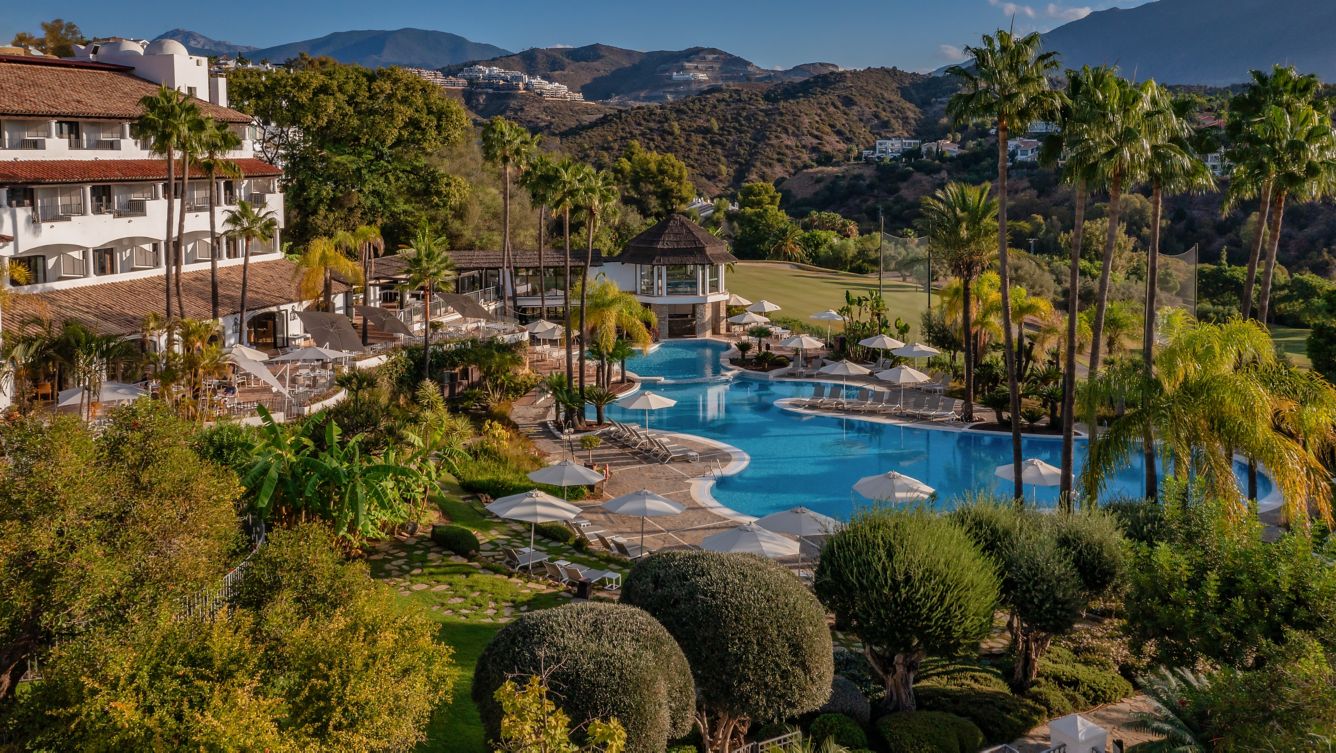 Resort-style pool surrounded by lush gardens and golf course views at La Quinta, Benahavís.