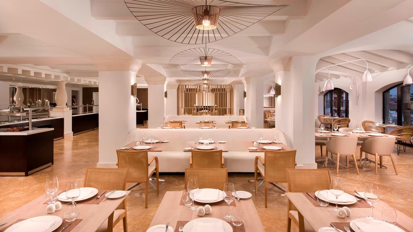 Elegant restaurant with a neutral palette, wooden accents, and modern pendant lighting.