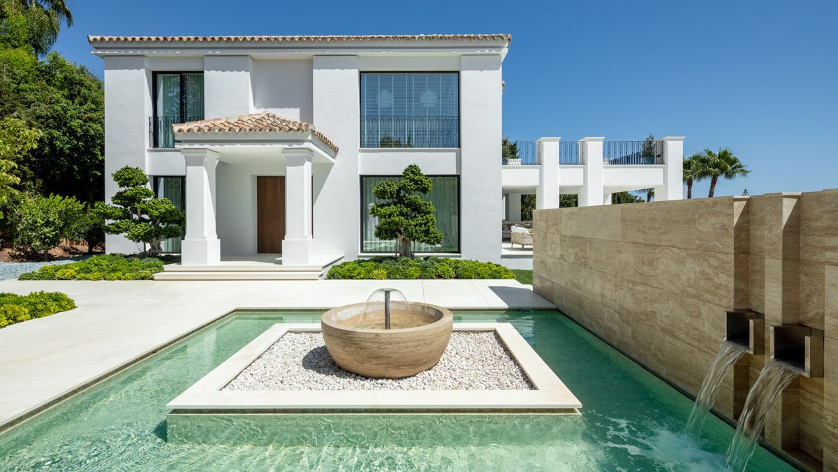 Elegant villa entrance in Sierra Blanca, Marbella, featuring a minimalist water feature, manicured gardens, and a modern Mediterranean façade.