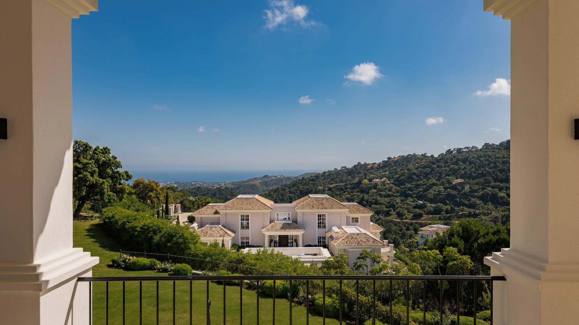 A view from a villa in La Zagaleta overlooking lush greenery and the Mediterranean Sea in the distance, capturing the beauty and tranquility of the surroundings.