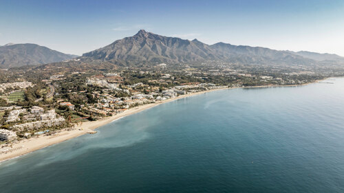 Aerial view of Marbella’s Golden Mile, featuring sandy beaches, luxury properties, and La Concha Mountain in the background.