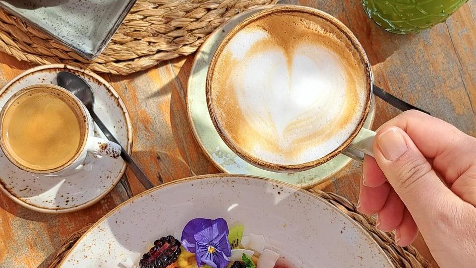 A colorful breakfast with a latte and a croissant.