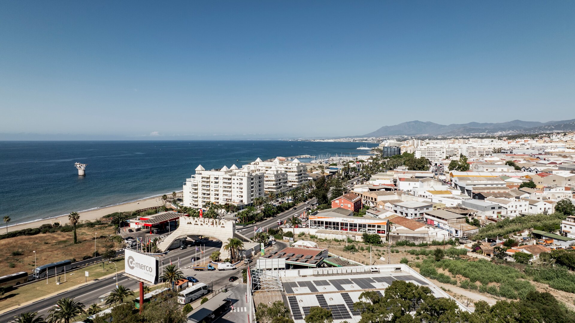 Aerial view of the entrance to Marbella, with the Mediterranean coastline stretching towards Puerto Banús and La Concha mountain in the background.