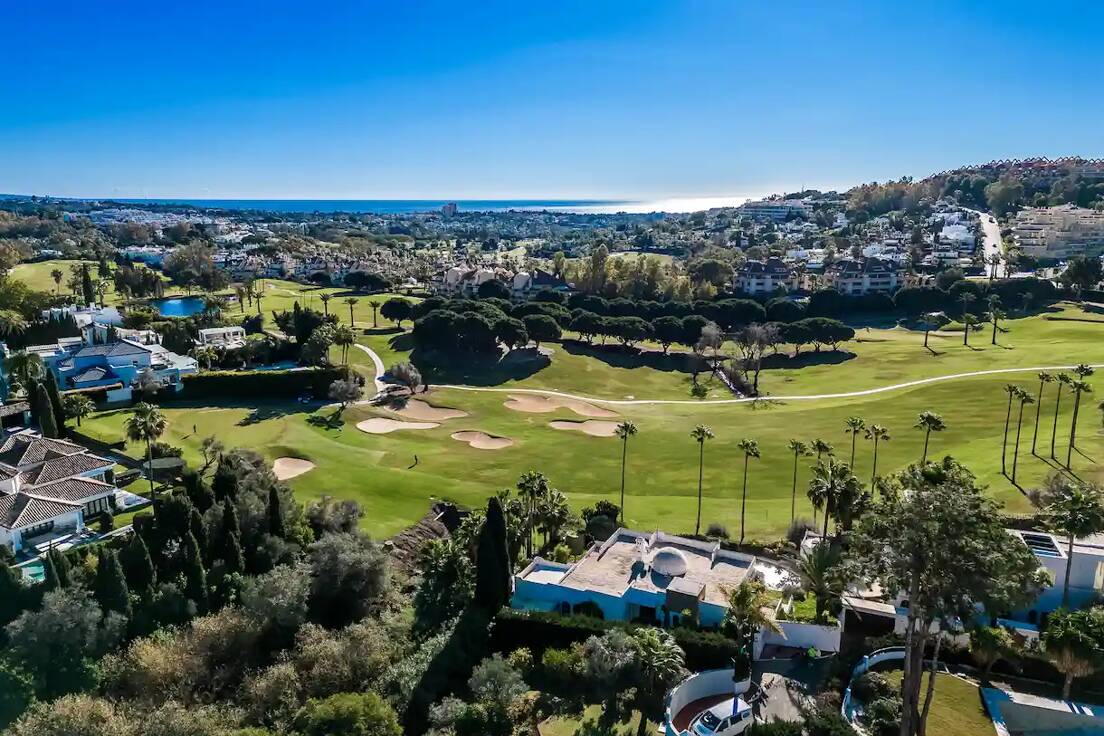 Villas and golf fairways in Nueva AndalucÃ­a, Marbella, with mediterranean sea in the background