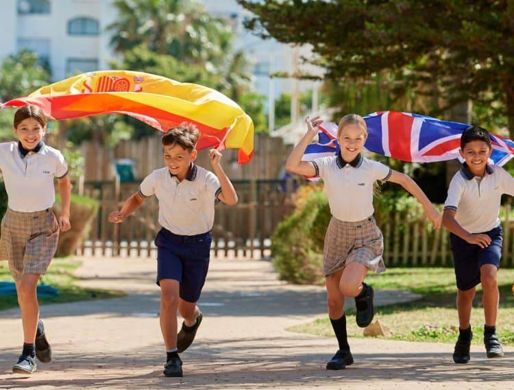 4 children running with the Spain and UK flags