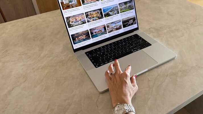 Luxury real estate website displayed on a MacBook, showcasing curated Marbella villas and premium property listings with elegant interface and refined browsing experience