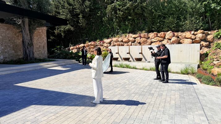 Team of Marbella Hills Homes filming a luxury property in Marbella, featuring Evelin Bentz presenting in a contemporary villa setting with professional video crew and outdoor modern architecture.