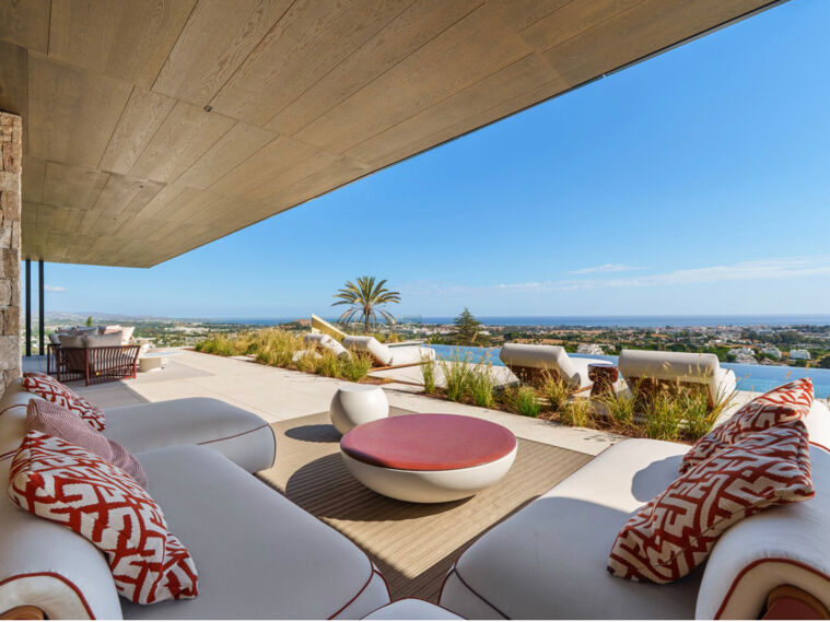 Luxury terrace with panoramic sea views in Marbella, featuring modern outdoor lounge seating, Mediterranean garden, and infinity-style horizon.