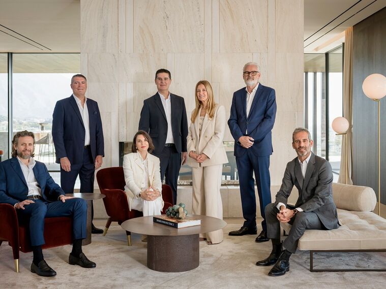 Luxury real estate team in Marbella standing on a modern villa terrace with infinity pool and panoramic sea views, representing a private and high-end property advisory on the Costa del Sol