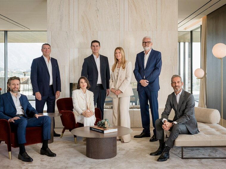 Luxury real estate team in Marbella standing on a modern villa terrace with infinity pool and panoramic sea views, representing a private and high-end property advisory on the Costa del Sol