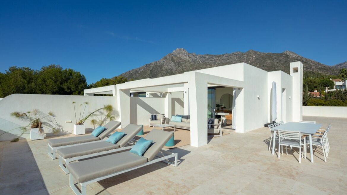 Dachterrasse eines Penthouses mit Sonnenliegen und der La Concha im Hintergrund