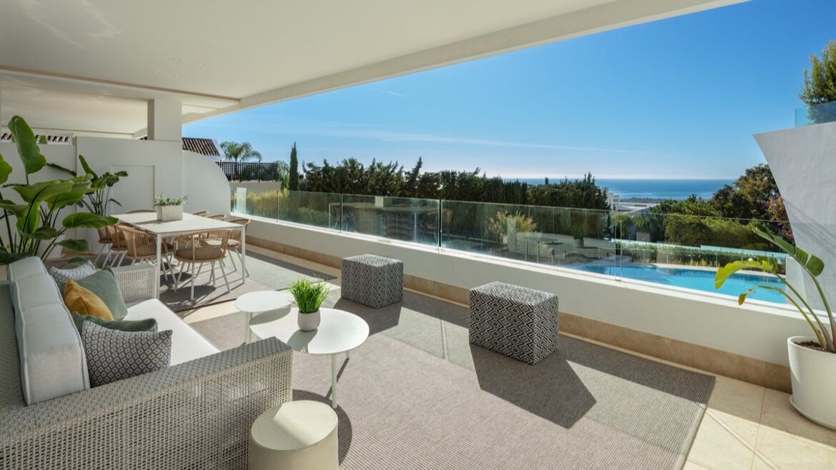 Terrassenlounge mit Blick über den Gemeinschaftspool aufs Meer