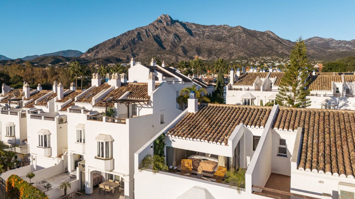 Reihenhäuser im andalusischen Stil mit dem Berg La Concha im Hintergrund in Altos de Puente Romano