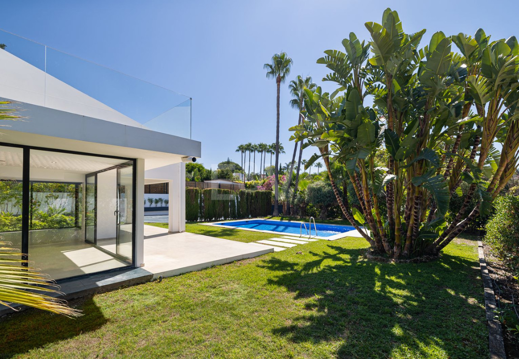 Villa elegante con piscina, jardín tropical y atractivo urbano