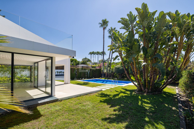 Villa elegante con piscina, jardín tropical y atractivo urbano