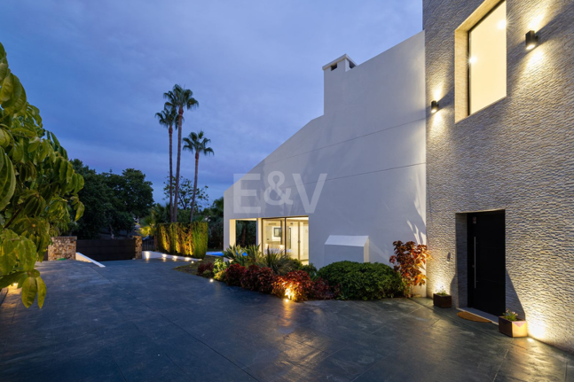 Villa elegante con piscina, jardín tropical y atractivo urbano